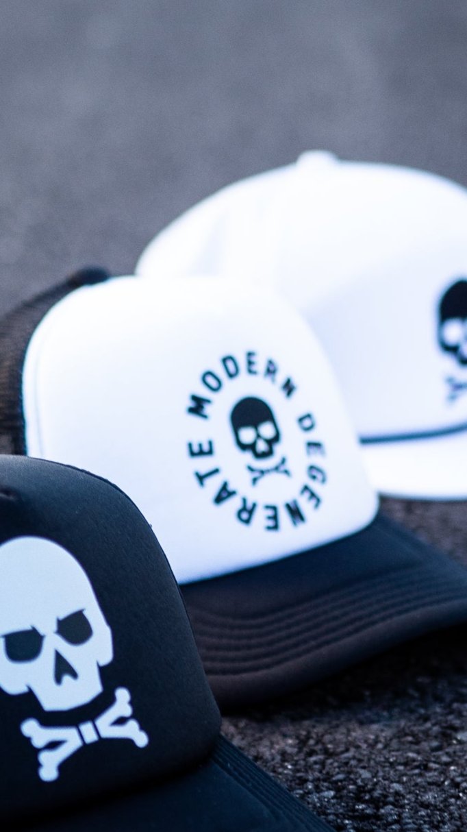 A trio of white and black hats with skulls on them