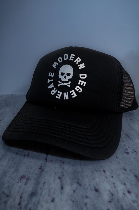 A black trucker cap with a skull and circle text logo