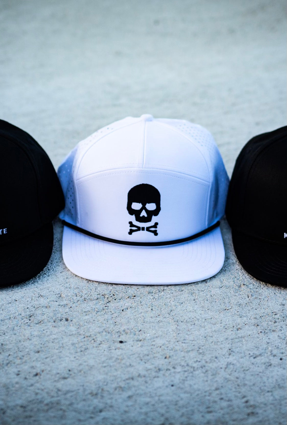 White flat brim hat with a black skull